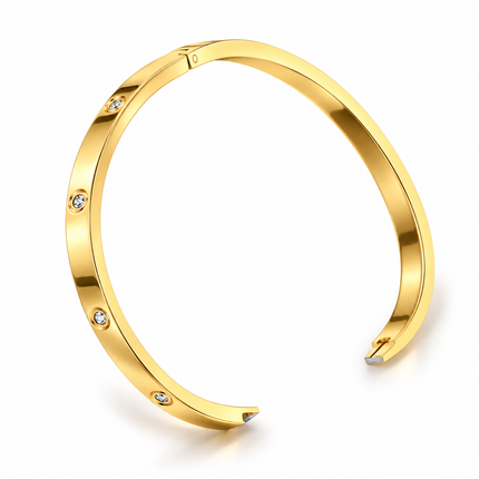A polished gold-tone open cuff bracelet with four small clear gemstones set along the front, shown on a clean white background.